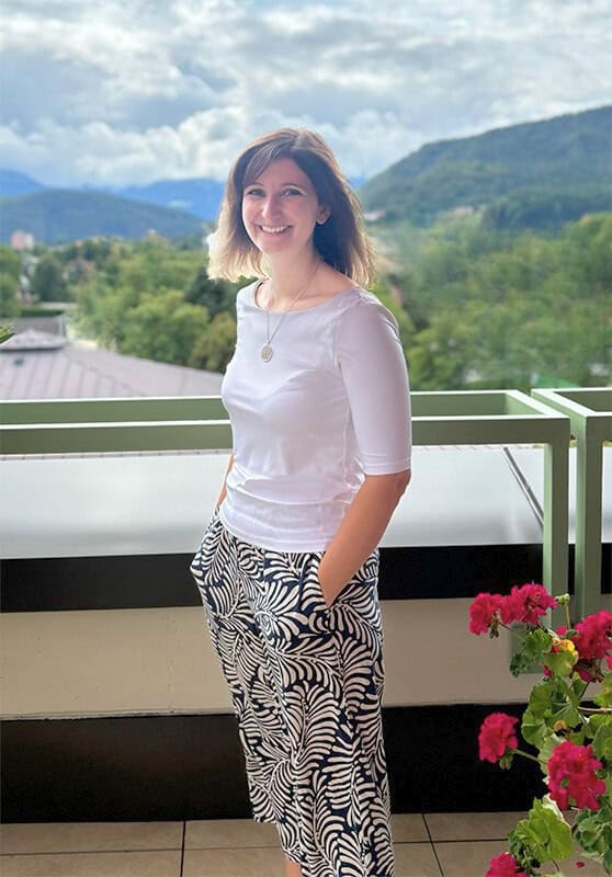 Acrylbilder Julia Magdalena, Künstlerin auf Balkon mit Bergblick im Hintergrund, moderne Acrylkunst, kreative Wanddekoration, künstlerische Malerei, hochwertige Acrylbilder, Kunstwerke für Zuhause, zeitgenössische Kunst.